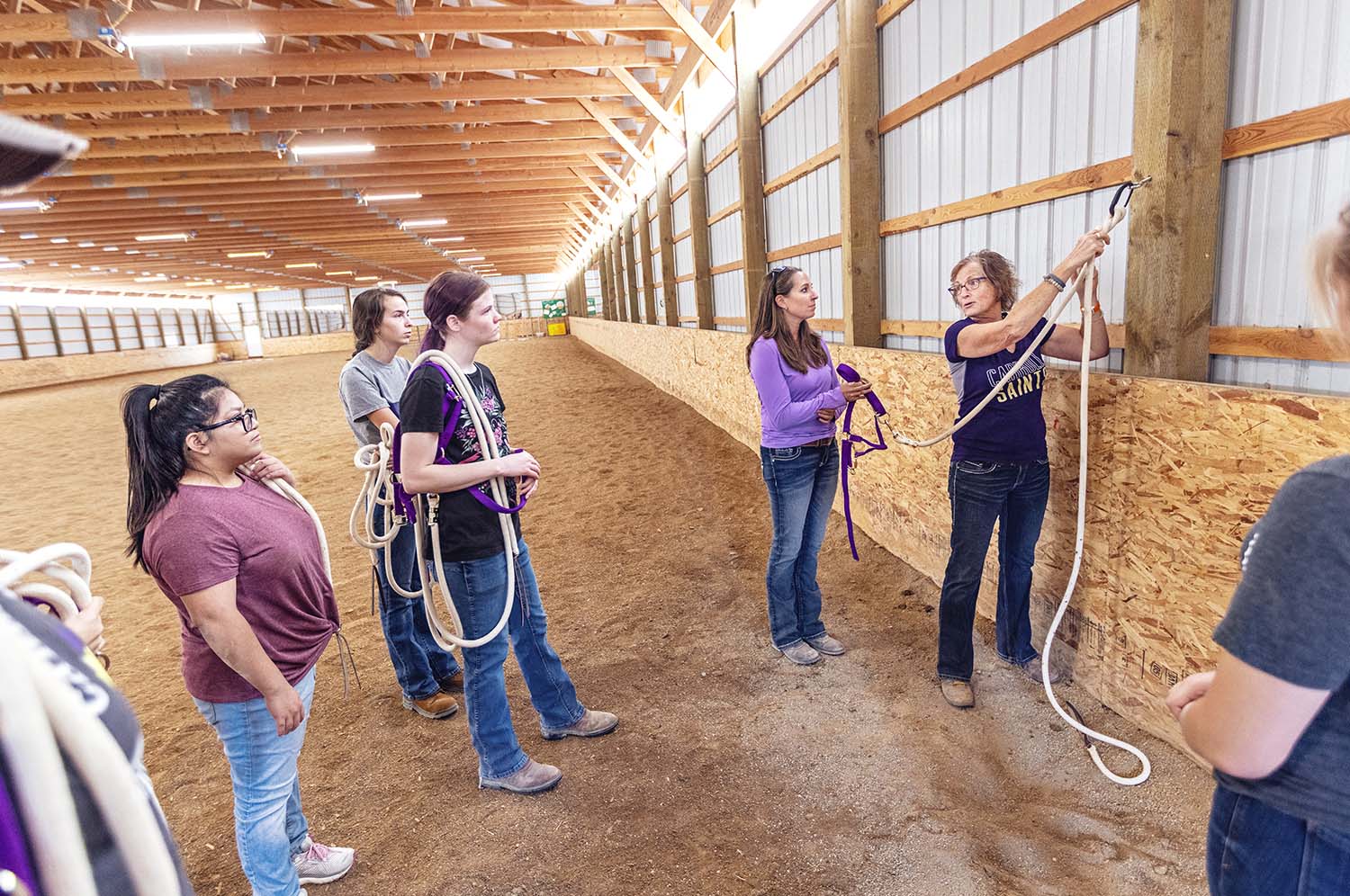 Professor and students in a horse stable during an Anthrozoology class
