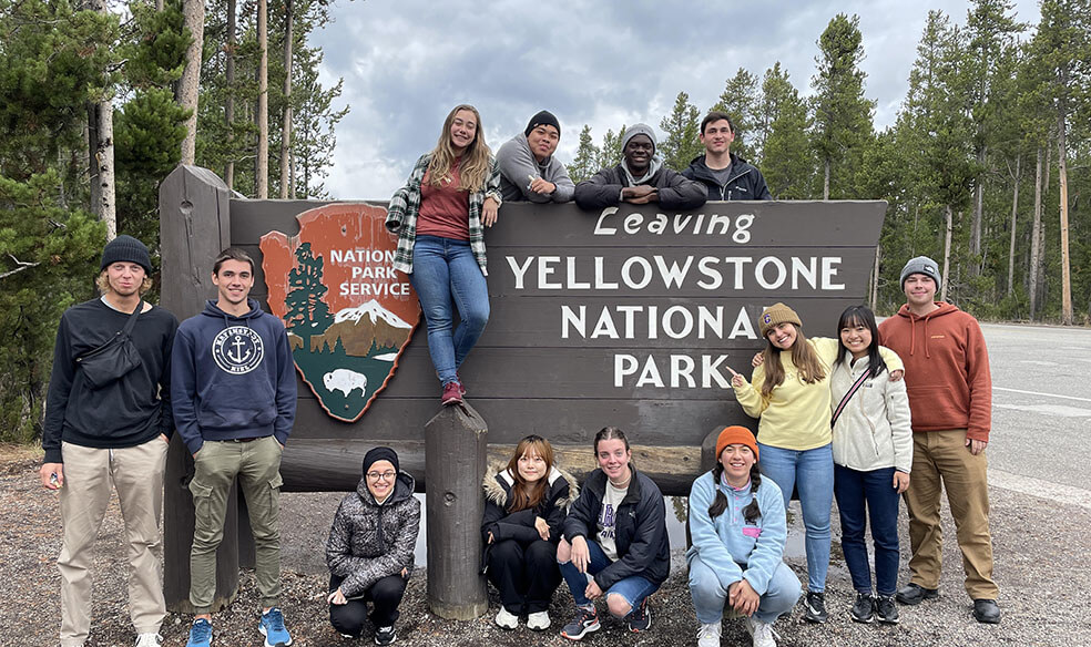 Diverse group of students standing at the entrance to Yellowstone National Park