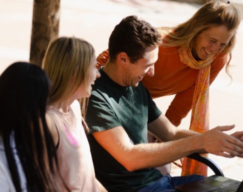 Students outside on bench with professor