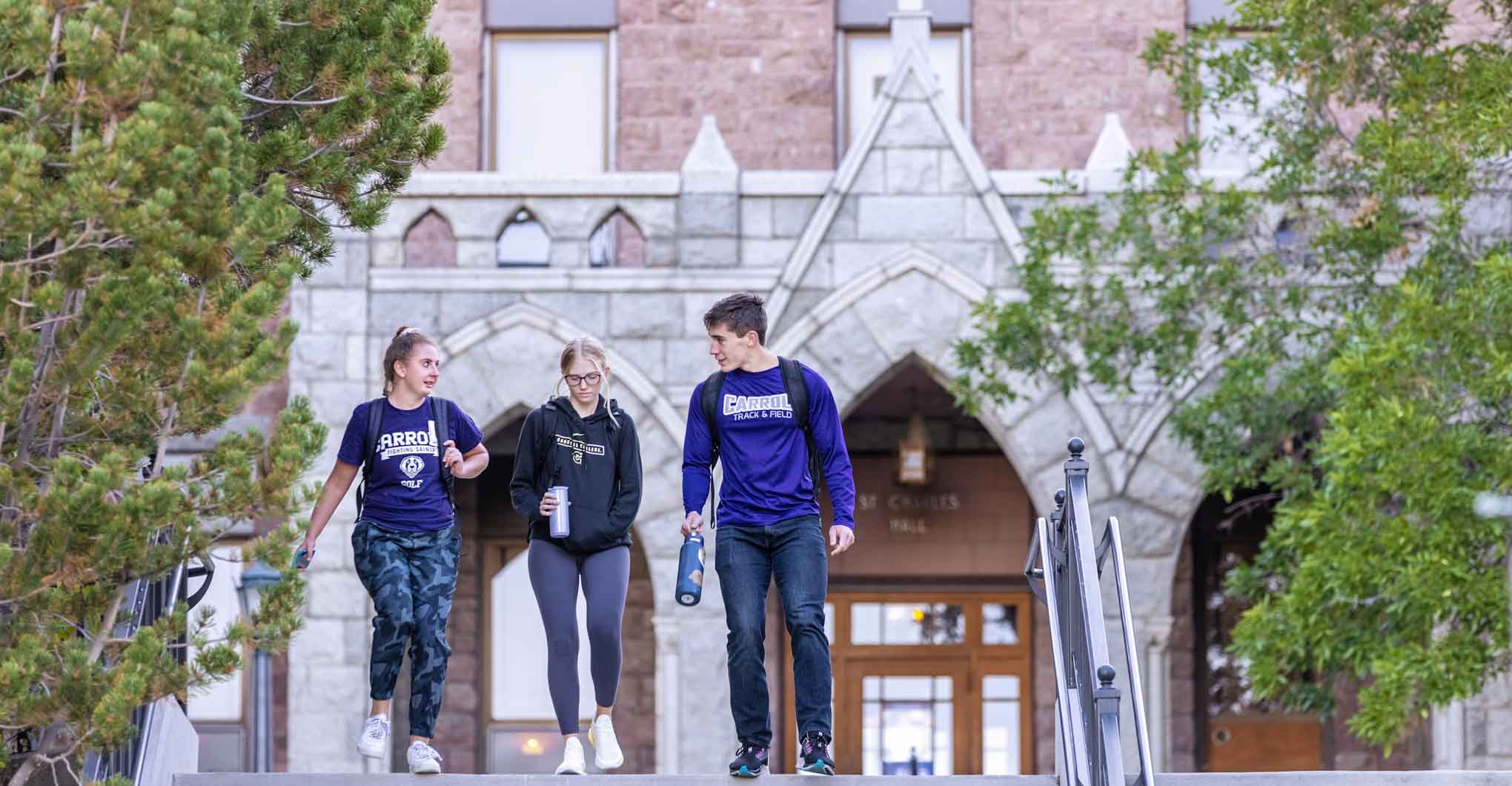 Three Students Walking Outside St. Charles Hall