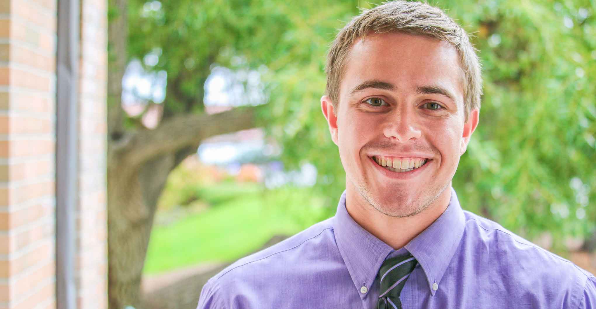 Male student in tie smiling - Pierce