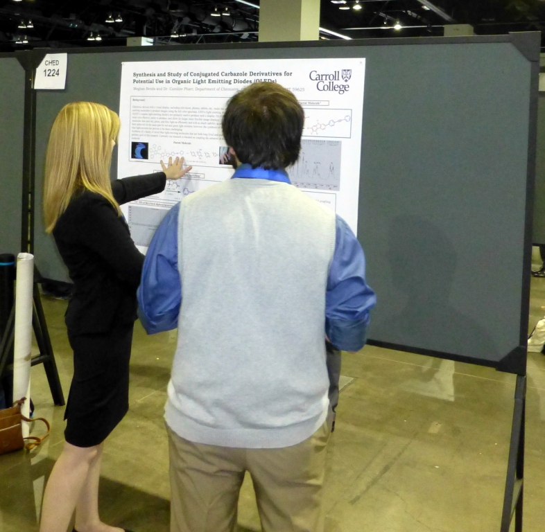 Meghan Benda explains her research poster to a passer by