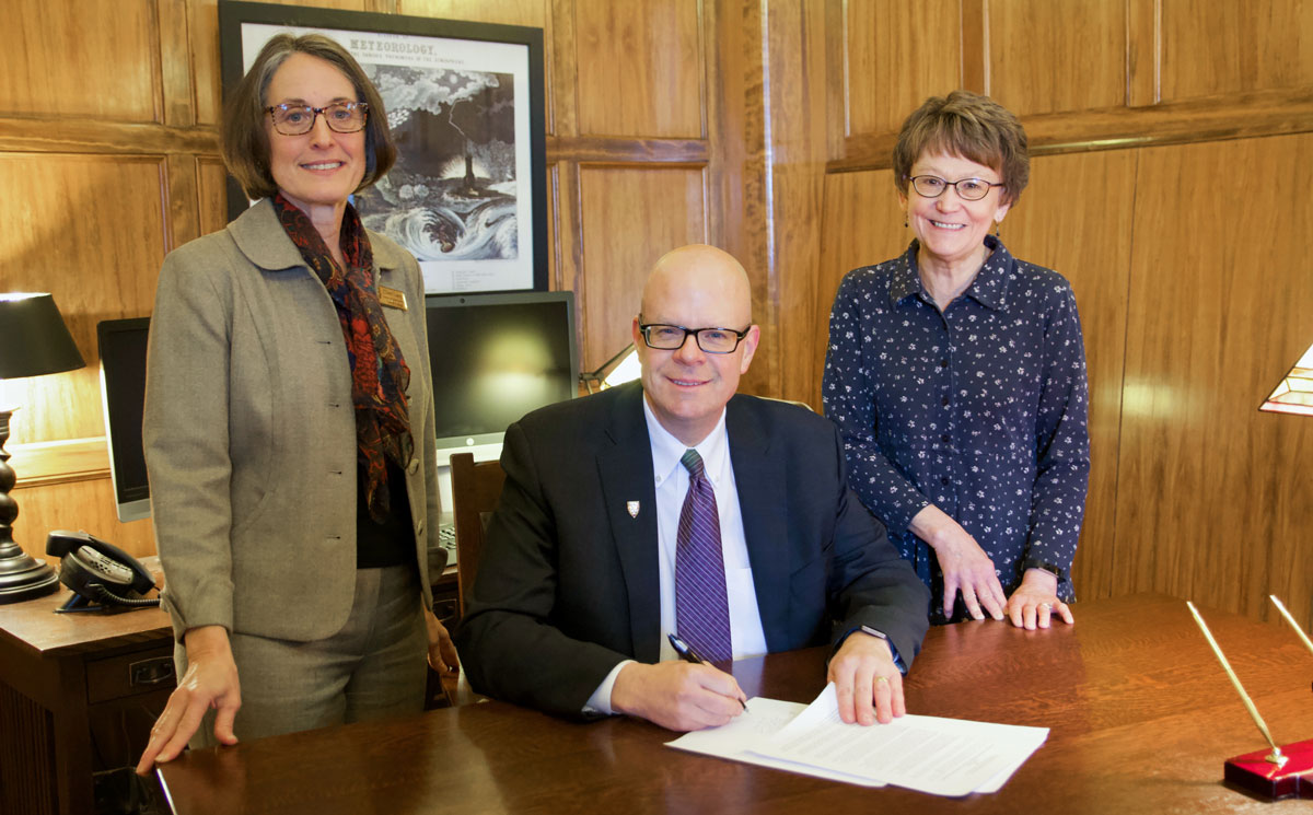 Cheri Long and Cathy Day with Dr. John Cech signing the agreement with Exeter College, Oxford