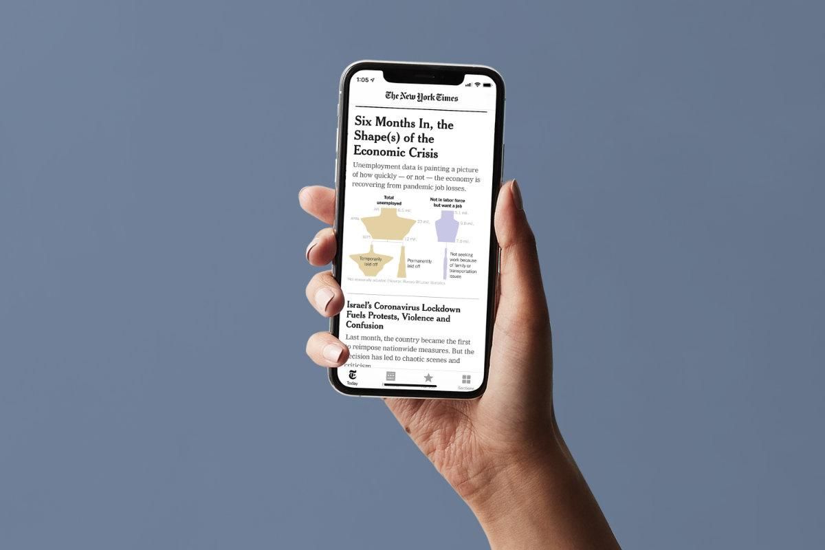 Photo of a hand holding a phone showing the New York Times app