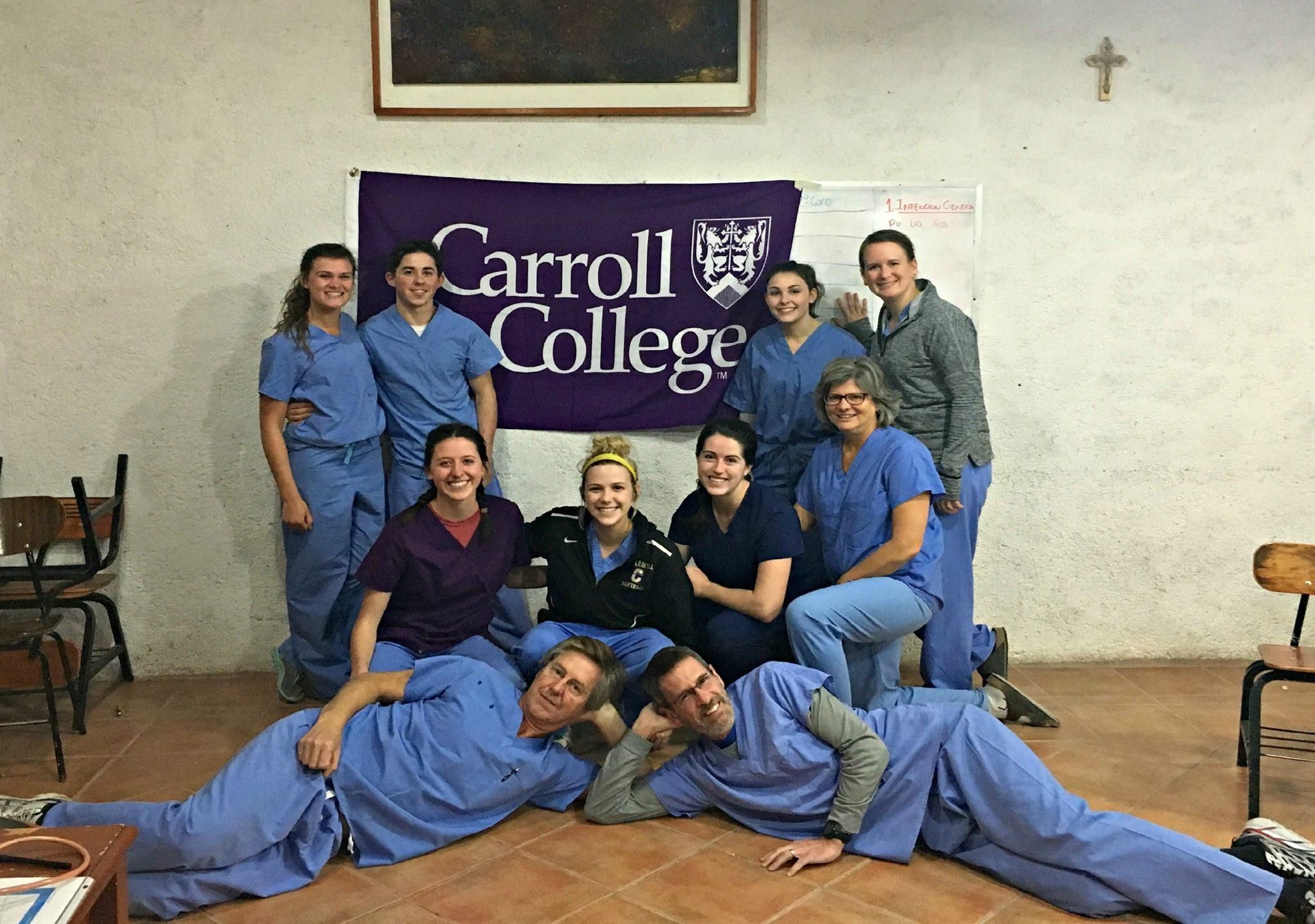 Carroll College Nursing Students pose next to a Carroll College Flag