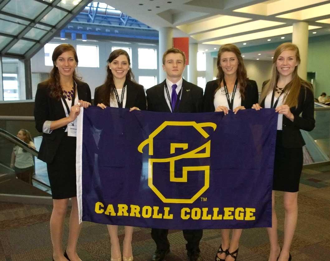 Carroll College Team poses with a Carroll Flag